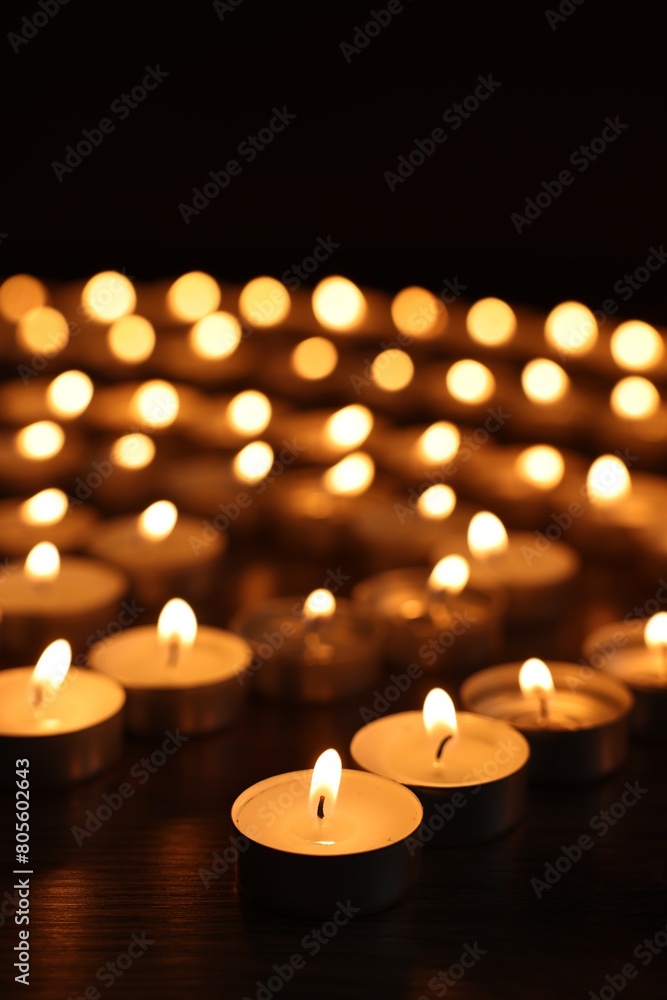 Burning candles on wooden table in darkness Burning candles on wooden table in darkness