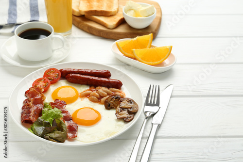 Delicious breakfast with sunny side up eggs served on white wooden table