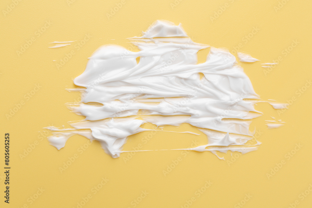 Sample of body care cream on yellow background, top view Sample of body care cream on yellow background, top view