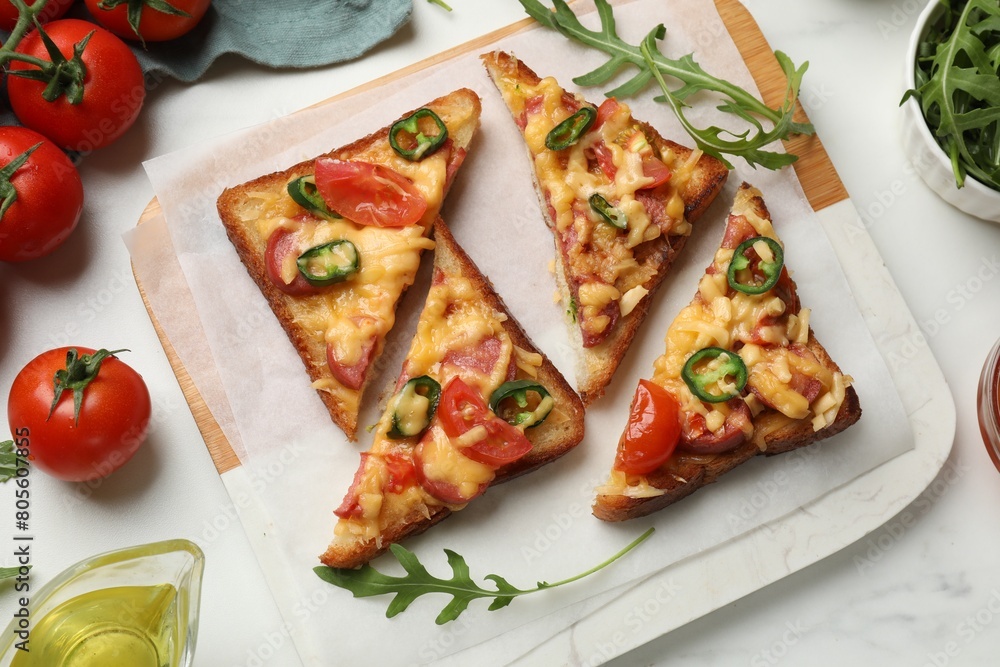 Tasty pizza toasts and ingredients on white marble table, flat lay Tasty pizza toasts and ingredients on white marble table, flat lay