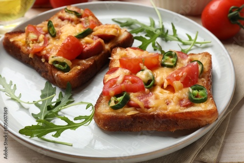 Tasty pizza toasts and ingredients on light wooden table, closeup