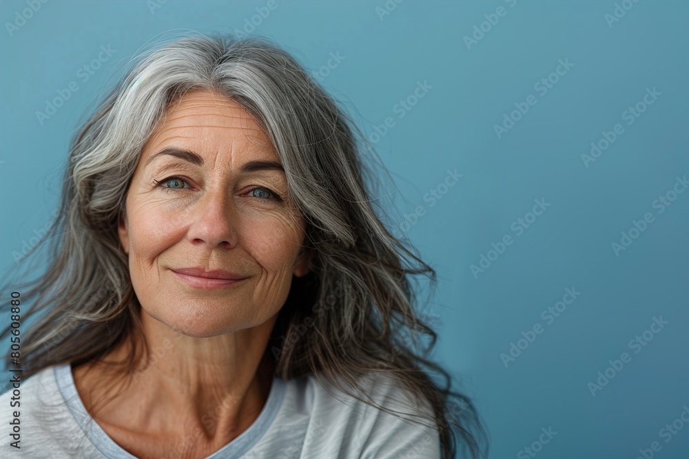 A woman with gray hair and a blue shirt is smiling A woman with gray hair and a blue shirt is smiling
