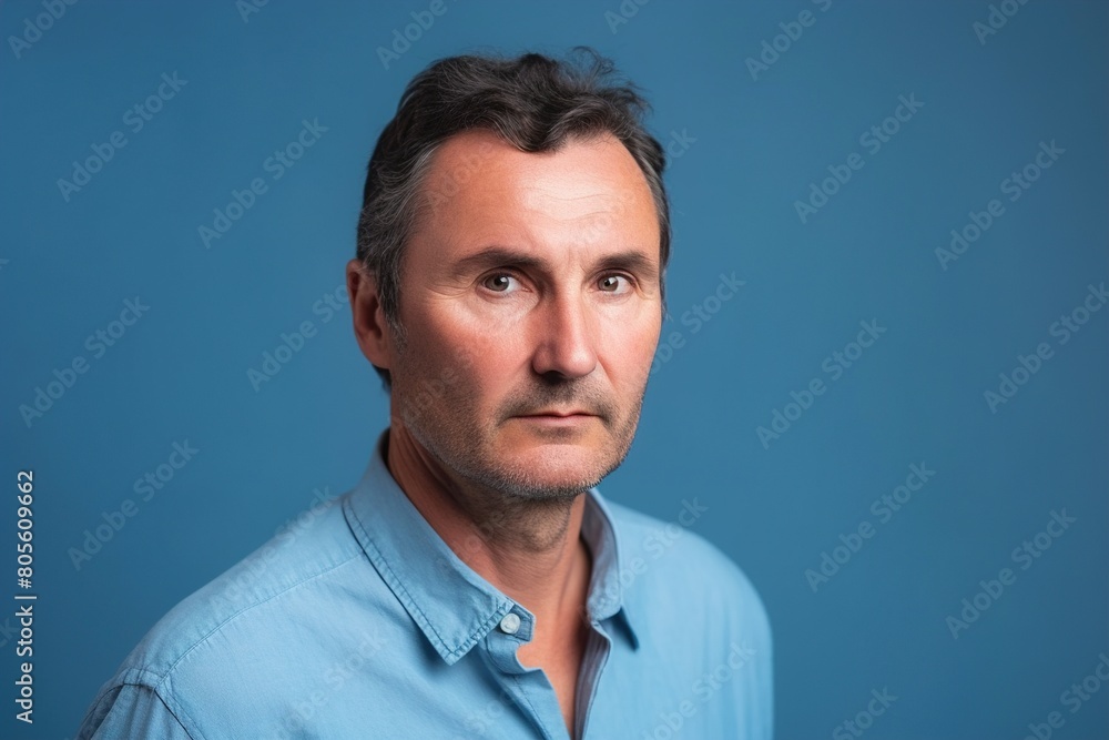 Obraz premium A man with a beard and gray hair is wearing a blue shirt