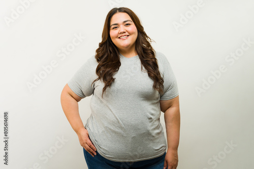 Foto Happy overweight Latin woman standing confidently in a studio while wearing a gr