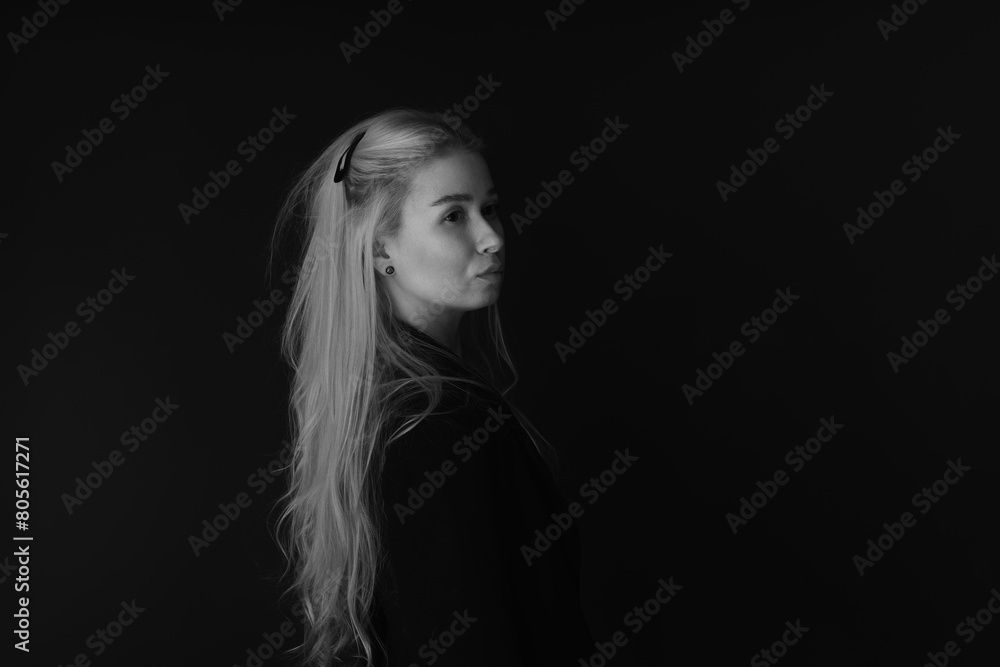 Black and white low key portrait of beautiful young blonde woman