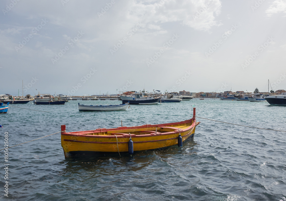 Yellow fishing boat in port of Marzamemi village on the island of Sicily, Italy