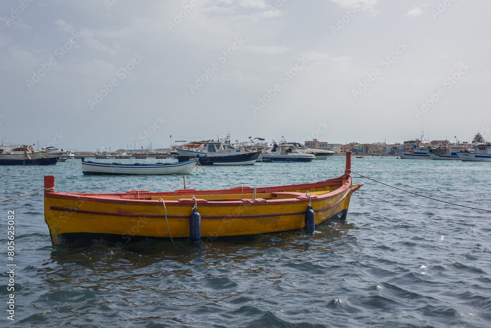 Yellow fishing boat in port of Marzamemi village on the island of Sicily, Italy