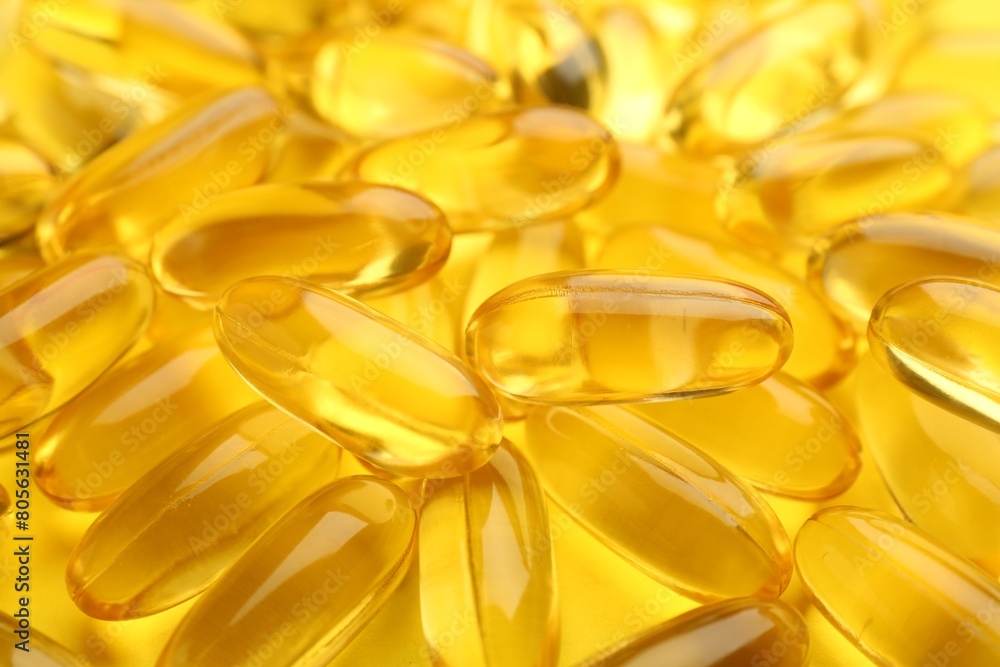 Many vitamin capsules on yellow background, closeup Many vitamin capsules on yellow background, closeup