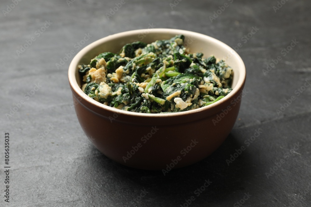 Tasty spinach dip with egg in bowl on black table, closeup Tasty spinach dip with egg in bowl on black table, closeup