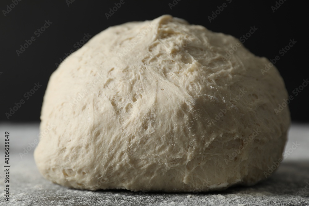 Raw homemade dough and flour on black table, closeup Raw homemade dough and flour on black table, closeup