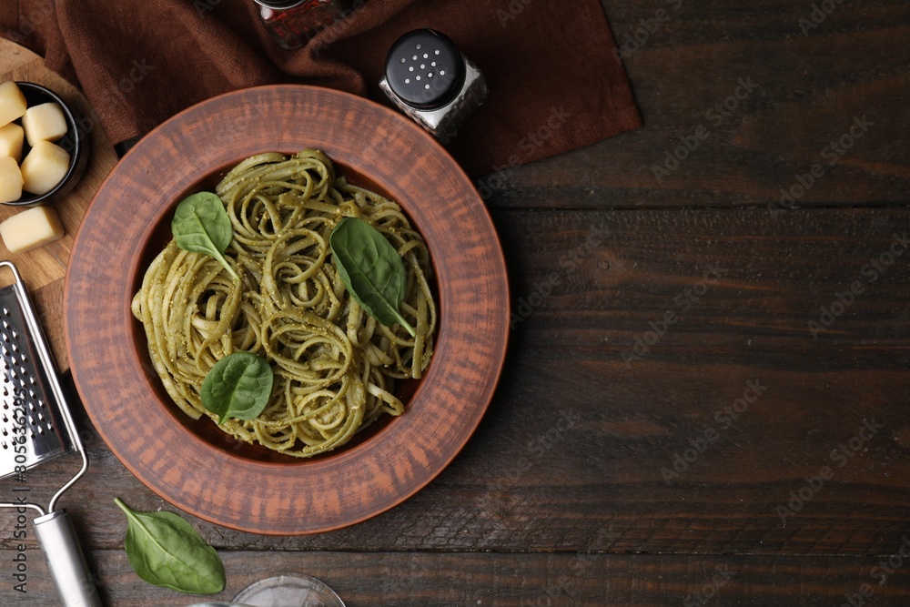 Tasty pasta with spinach served on wooden table, flat lay. Space for text