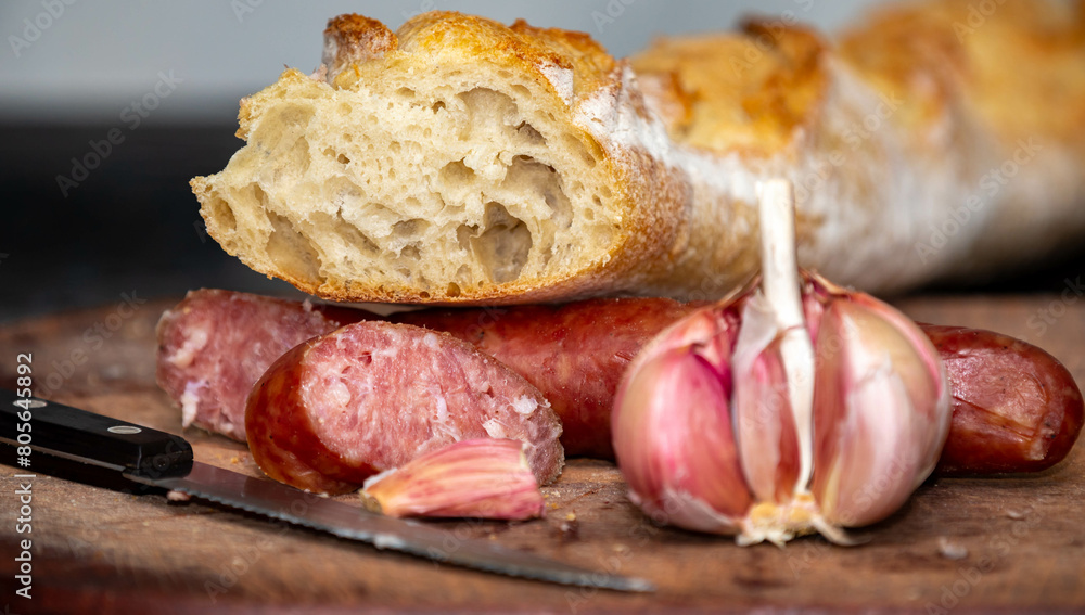 Rustic bread with salami and garlic on wooden board