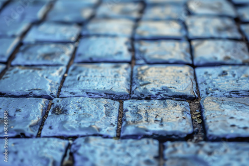 A blue tiled surface with a wet appearance. The tiles are arranged in a grid pattern, and the water droplets on the surface create a sense of movement and energy