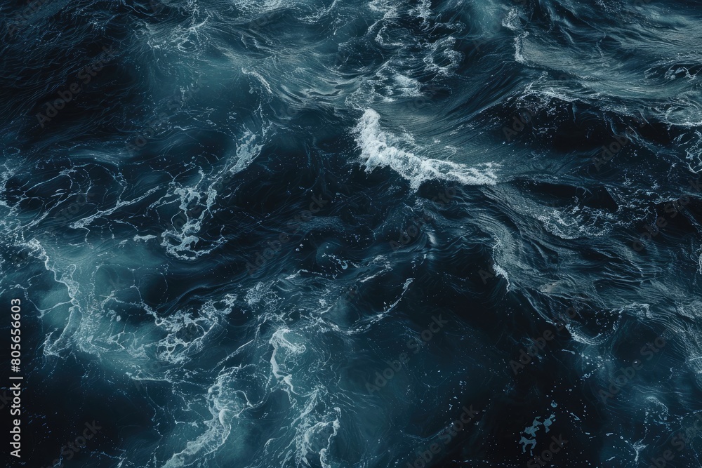 The image is of a large body of water with waves crashing against the shore. The water is dark blue and he is calm, with no visible signs of turbulence