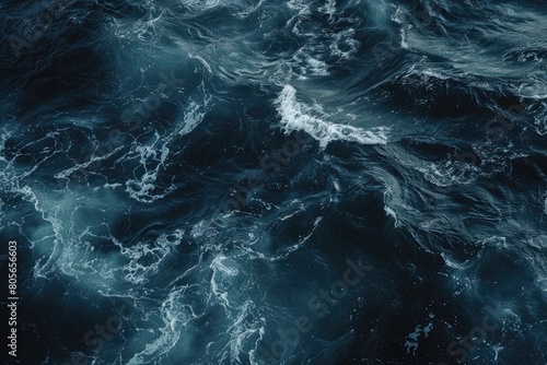 The image is of a large body of water with waves crashing against the shore. The water is dark blue and he is calm, with no visible signs of turbulence