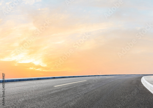 Modern highway cutting through the countryside under a clear blue sky