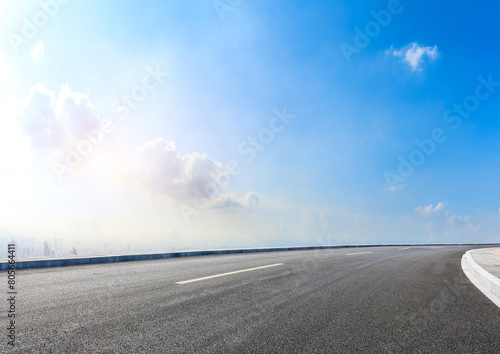 Modern highway cutting through the countryside under a clear blue sky