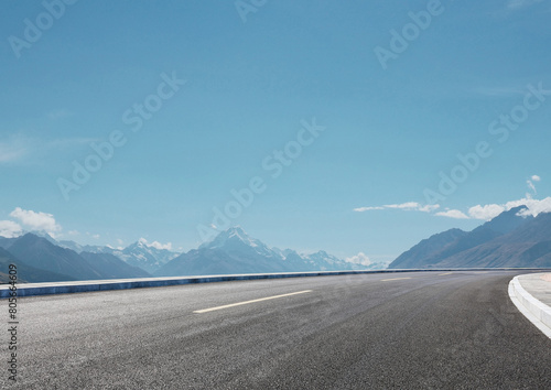 Modern highway cutting through the countryside under a clear blue sky
