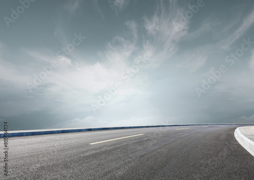 Modern highway cutting through the countryside under a clear blue sky