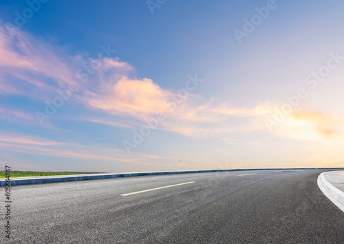 Modern highway cutting through Asian countryside under a clear blue sky