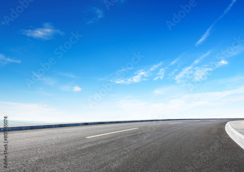 Modern highway cutting through Asian countryside under a clear blue sky