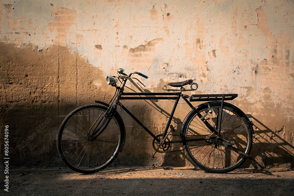 Vintage old bicycle leaning against dirty old wall background. Classic bike on decay wall with retro style.