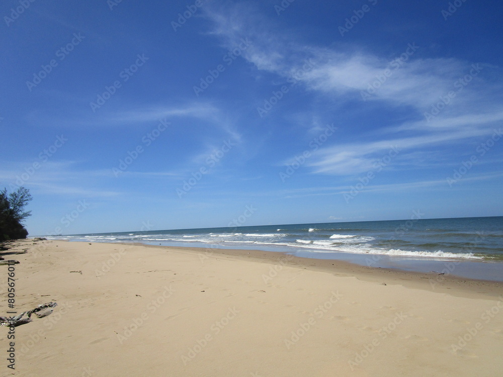 endless sand and sea under blue skies and wispy clouds endless sand and sea under blue skies and wispy clouds