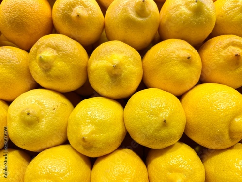close-up of yellow lemons stacked on the display of an organic producer 