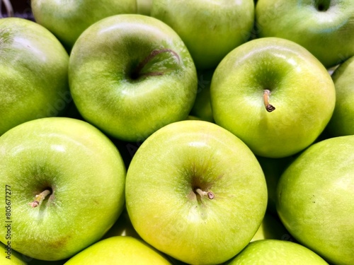 close-up of green apples stacked on the display of an organic producer 