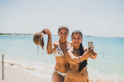 pareja de mujeres hispanoamericanas de vacaciones en la playa tomando auto foto  photo