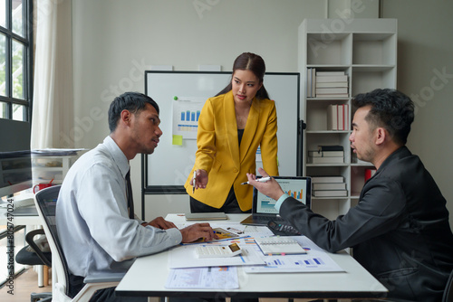 An operations manager presents a meeting to a team of economists using a whiteboard with growth analysis, charts, statistics, and data. Worker concept in a startup business office.