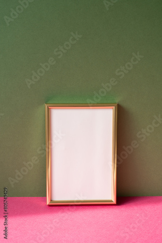 Obraz na płótnie Gold picture frame with copy space on pink table. khaki green wall background w salonie