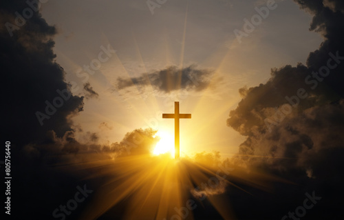 Cross of Jesus Christ with sun rays coming out of the clouds.