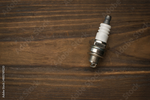 An internal combustion engine spark plug on a wooden background. photo