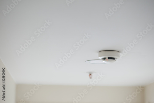 White smoke detector on ceiling at home 