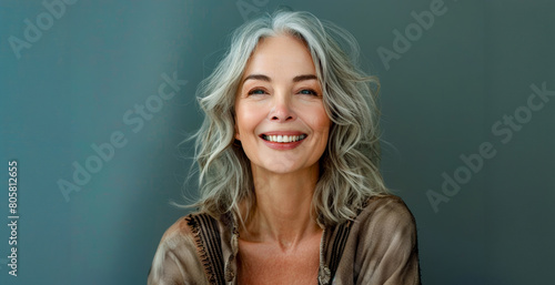 A woman with gray hair is smiling and wearing a brown sweater © Mr. Stocker