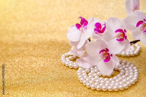 A branch of white orchids on a shiny gold background