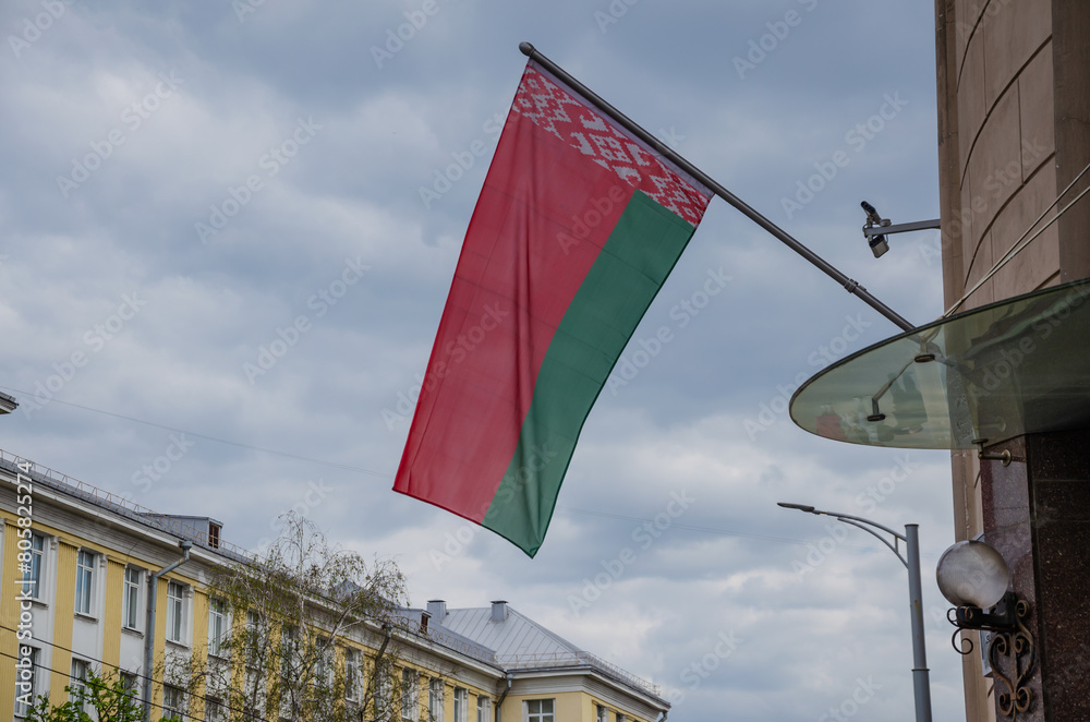 red-green Belarusian flag on the wall of a house against the blue sky, Republic of Belarus