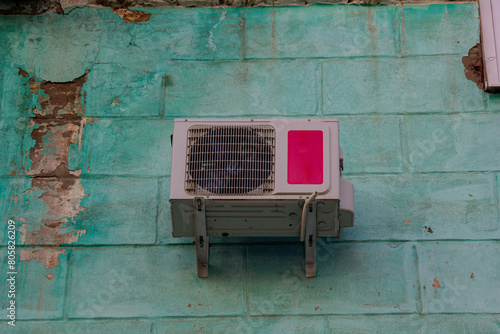 Bottom view of the air conditioner mounted on a green light wall.