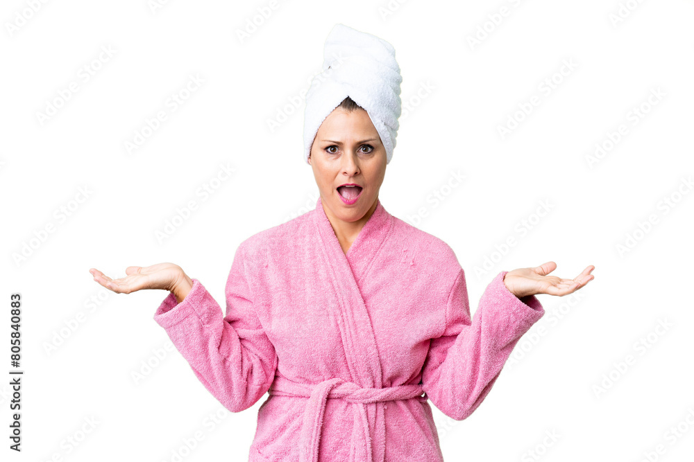 Middle age caucasian woman in a bathrobe over isolated background with shocked facial expression Middle age caucasian woman in a bathrobe over isolated background with shocked facial expression