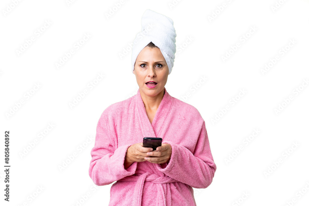 Middle age caucasian woman in a bathrobe over isolated background surprised and sending a message Middle age caucasian woman in a bathrobe over isolated background surprised and sending a message