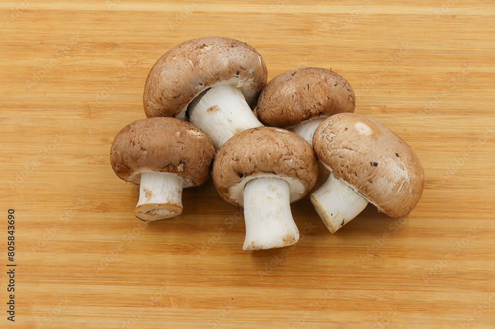 Fresh champignon mushroom isolated on wooden background Fresh champignon mushroom isolated on wooden background