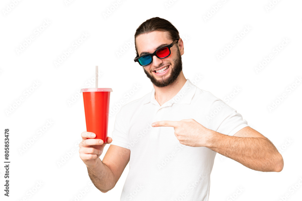 Young handsome man holding soda while watching a 3D movie over isolated chroma key background and pointing it Young handsome man holding soda while watching a 3D movie over isolated chroma key background and pointing it