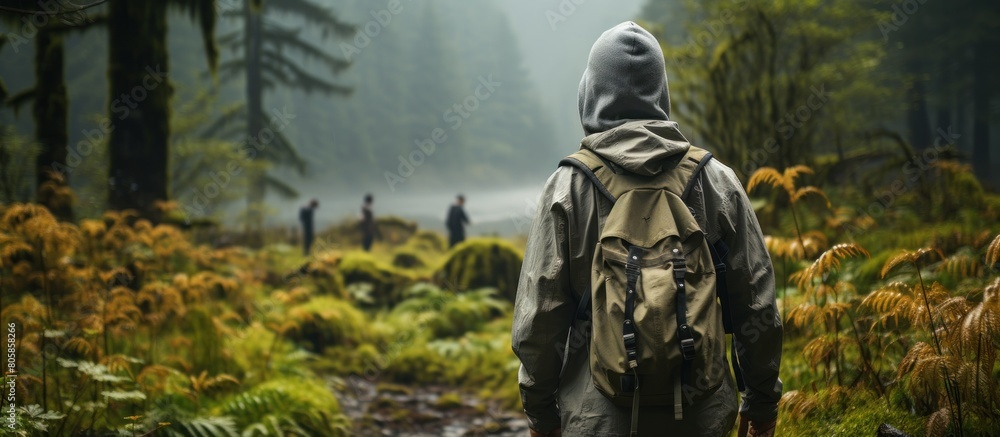 Digital composite of Hiker with backpack looking at misty forest.
