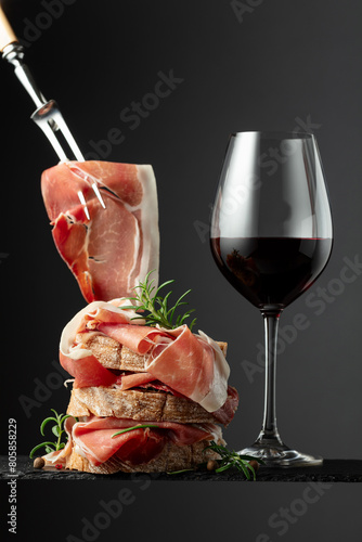 Ciabatta with prosciutto, rosemary and glass of red wine.