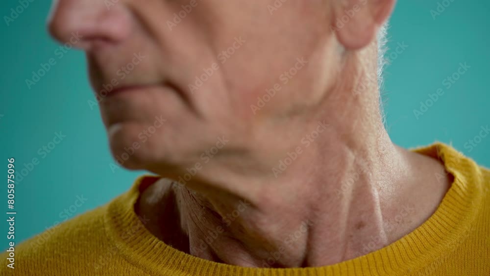 Old man turning the head left and right. Doing strengthening exercise for the neck, on blue background Old man turning the head left and right. Doing strengthening exercise for the neck, on blue background