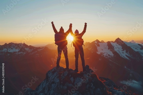 Three individuals are triumphantly raising their hands in the air, standing atop a mountain peak, exuding joy and pride in their accomplishments.