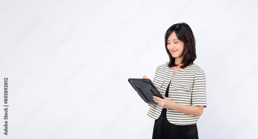 Asian woman is using a tablet against a white background.