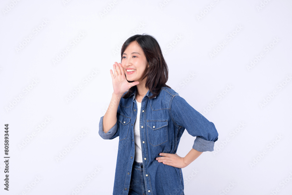 Asian woman wearing denim jean is posing with a shouting gesture against a white background. Asian woman wearing denim jean is posing with a shouting gesture against a white background.