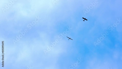 Segelflugzeug wird von Motorflugzeug in den Himmel gezogen. Flugsport, Luftfahrt, Hobbyflieger und Segelflieger symbolisiert durch Flugzeuge vor blauem Himmel photo